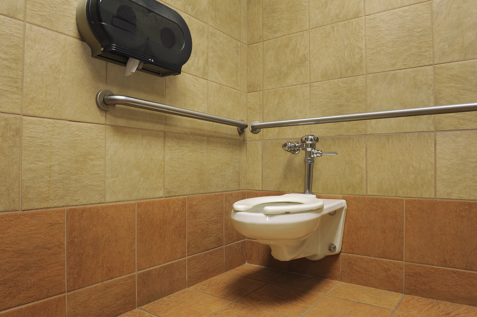 toilet cubicles - white toilet in a beautiful brown-tiled public restroom
