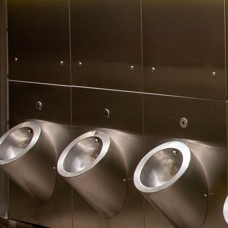stainless steel urinal trough - Row-Of-Modern-Stainless-Steel-Urinals-In-A-Public-Bathroom