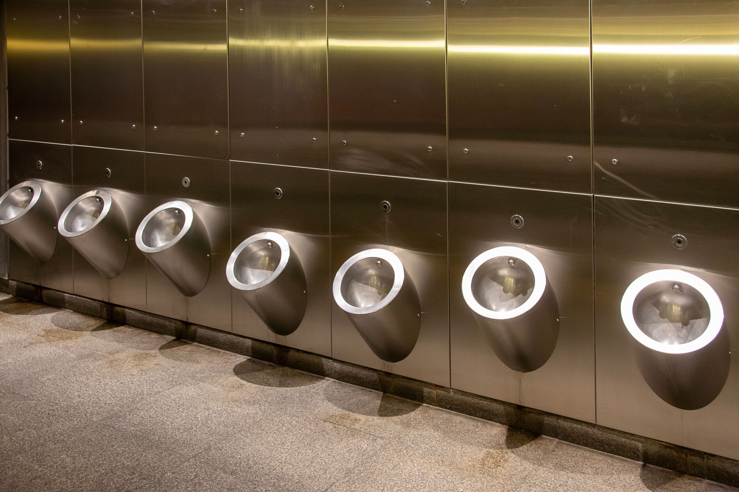 stainless steel urinal trough - Row-Of-Modern-Stainless-Steel-Urinals-In-A-Public-Bathroom